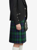 Person wearing a black jacket and green plaid kilt on a white background
