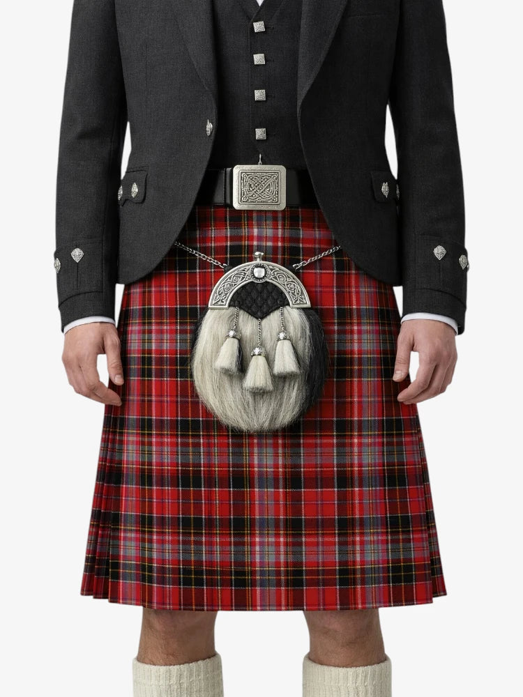 Person wearing a red tartan kilt with a black jacket and white shirt on a white background