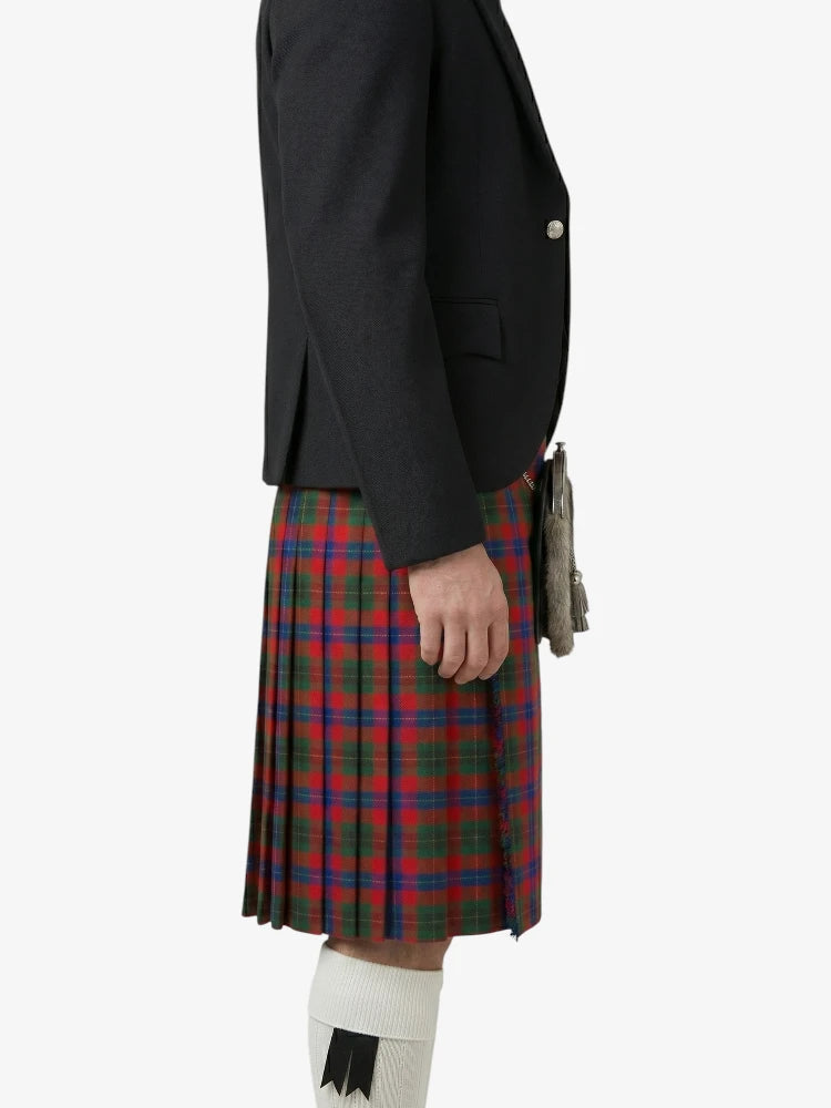 Person wearing a black jacket and red plaid kilt on a white background