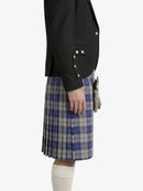 Person wearing a black blazer and blue plaid kilt on a white background