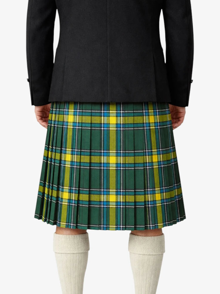 Person wearing a black jacket and green plaid kilt on a white background