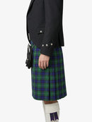 Person wearing a dark jacket and green plaid kilt on a white background