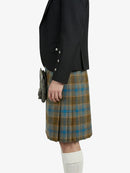 Person wearing a black jacket and plaid kilt on a white background