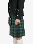 Person wearing a black blazer and green plaid kilt on a white background