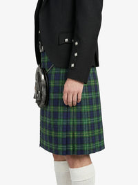 Person wearing a black blazer and green plaid kilt on a white background