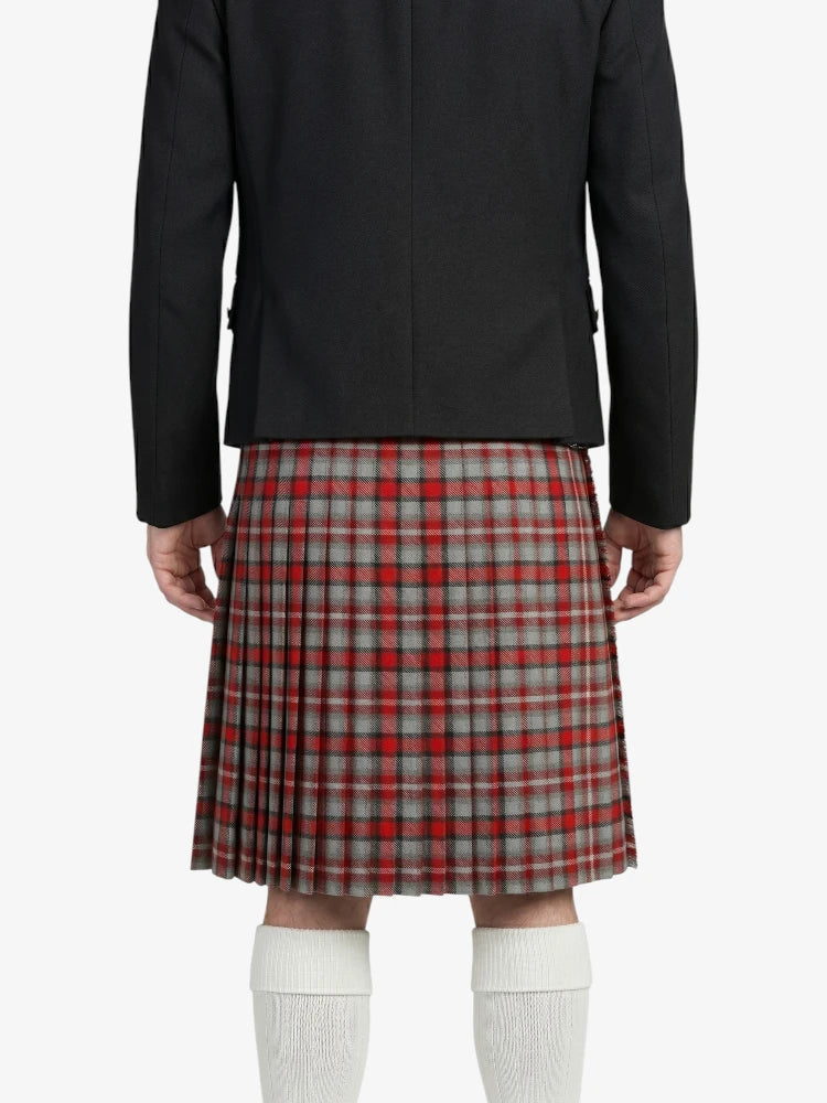 Person wearing a black jacket and red plaid kilt on a white background