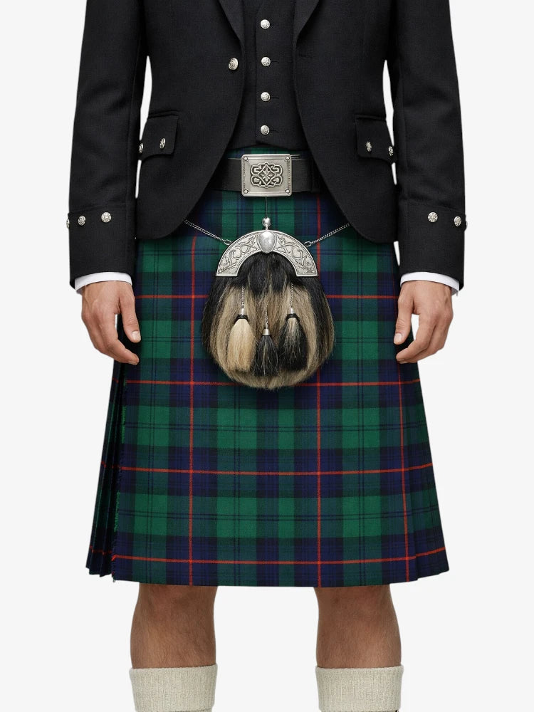 Person wearing a traditional Scottish kilt with a tartan pattern on a white background