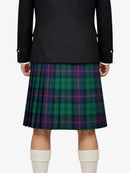 Person wearing a black jacket and green plaid kilt on a white background