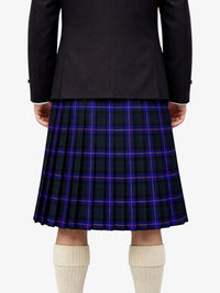 Person wearing a black jacket and plaid kilt on a white background