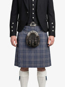 Person wearing a traditional Scottish kilt with a jacket on a white background