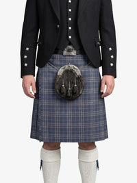Person wearing a traditional Scottish kilt with a jacket on a white background