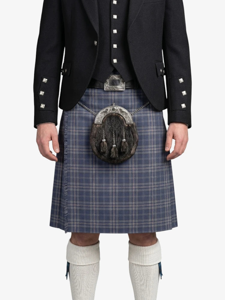 Person wearing a traditional Scottish kilt with a jacket on a white background
