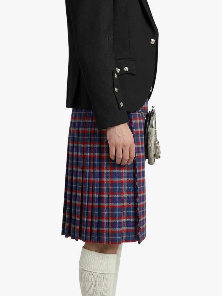 Person wearing a black jacket and red plaid kilt on a white background