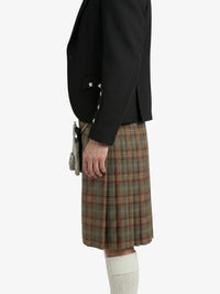 Person wearing a black blazer and plaid kilt on a white background