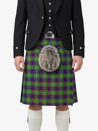 Person wearing a traditional Scottish kilt with a tartan pattern on a white background