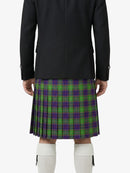 Person wearing a black coat and green plaid kilt on a white background