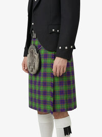 Person wearing a black jacket, green and purple plaid kilt, and white knee-high socks on a white background