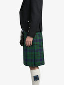 Person wearing a black jacket and green plaid kilt on a white background