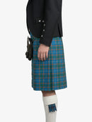 Person wearing a black jacket and blue plaid kilt on a white background