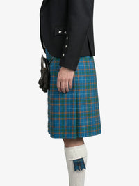 Person wearing a black jacket and blue plaid kilt on a white background