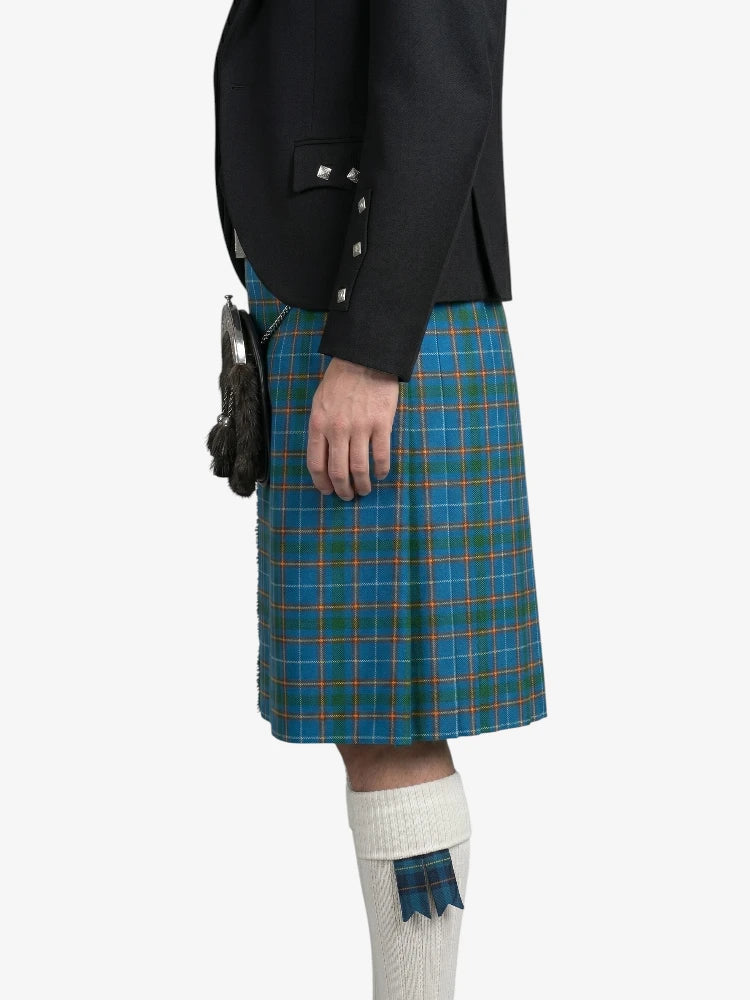 Person wearing a black jacket and blue plaid kilt on a white background