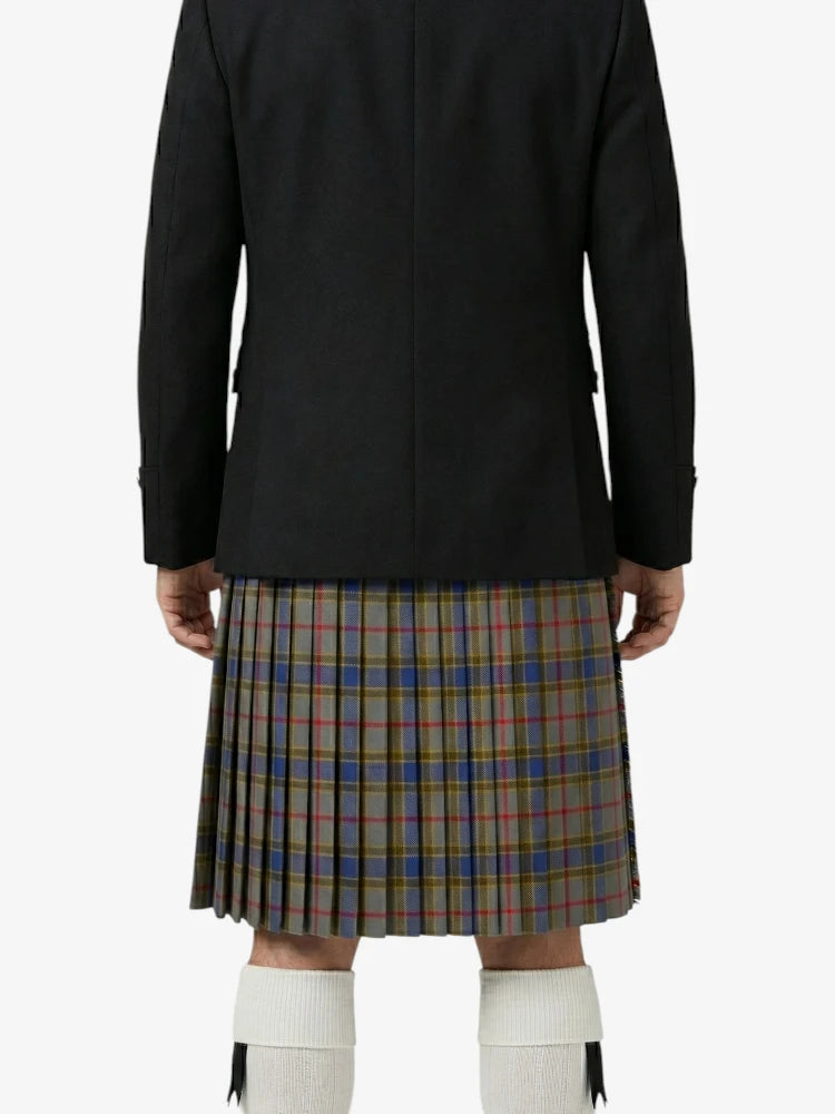 Person wearing a black jacket and plaid kilt on a white background