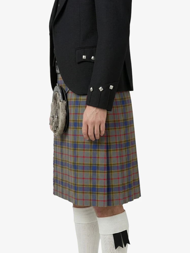 Person wearing a black jacket and plaid kilt on a white background