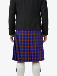 Person wearing a black jacket and purple plaid kilt on a white background