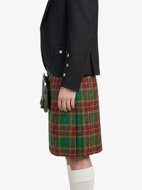 Person wearing a black blazer and green plaid kilt on a white background