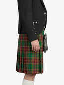 Person wearing a black jacket and green plaid kilt on a white background