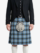 Person wearing a blue plaid kilt with a black jacket on a white background