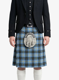 Person wearing a blue plaid kilt with a black jacket on a white background