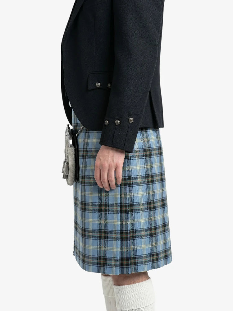 Person wearing a black jacket and blue plaid kilt on a white background