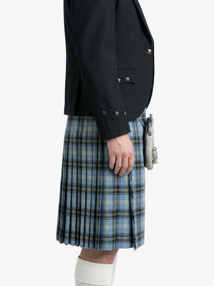 Person wearing a black jacket and blue plaid kilt on a white background