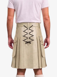 A beige pleated kilt with black lace-up detailing on the back, shown on a model wearing a light pink t-shirt against a white background.