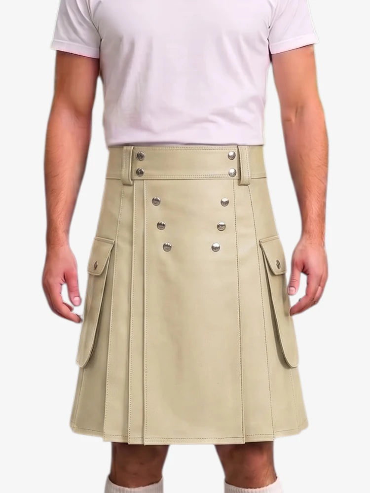A model wearing a light beige faux-leather kilt with silver-tone decorative buttons and side flap pockets, paired with a light pink t-shirt against a plain white background.