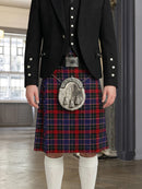 Person wearing a traditional Scottish kilt with a jacket and white socks indoors.