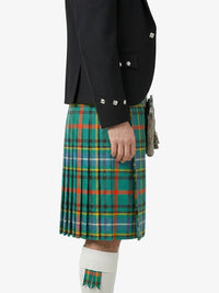 Person wearing a green plaid kilt with a black jacket on a white background