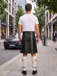 A man viewed from behind wearing a black leather kilt with a lace-up back, a white t-shirt, white knee-high socks, and black shoes, standing on a city sidewalk.