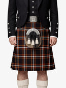 Person wearing a traditional Scottish kilt with a tartan pattern on a white background