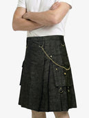 Person wearing a black kilt with gold accents on a white background
