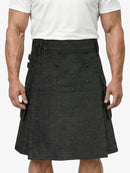 Person wearing a black kilt on a plain background