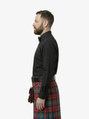 Man wearing a black shirt and red plaid kilt on a white background