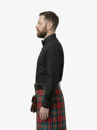 Man wearing a black shirt and red plaid kilt on a white background