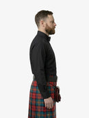 Man wearing a black shirt and plaid kilt on a white background