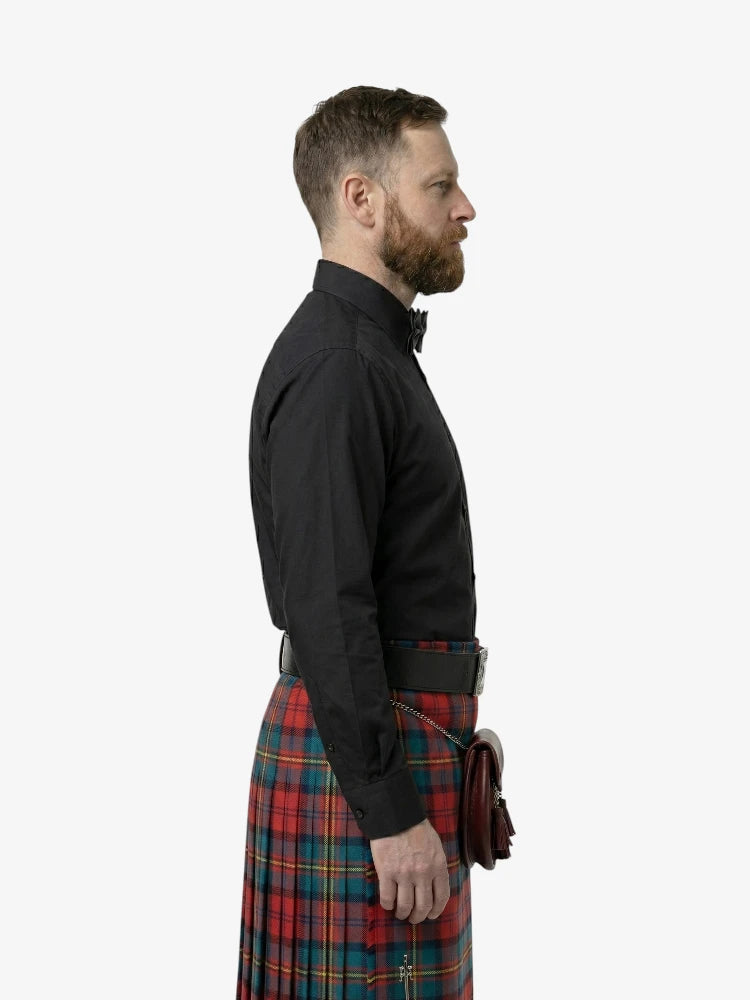 Man wearing a black shirt and plaid kilt on a white background