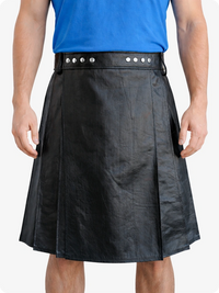 Person wearing a black leather kilt with a blue shirt on a white background