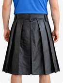 Person wearing a black pleated skirt and blue top on a white background