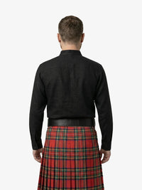 Man wearing a black shirt and red plaid kilt on a white background