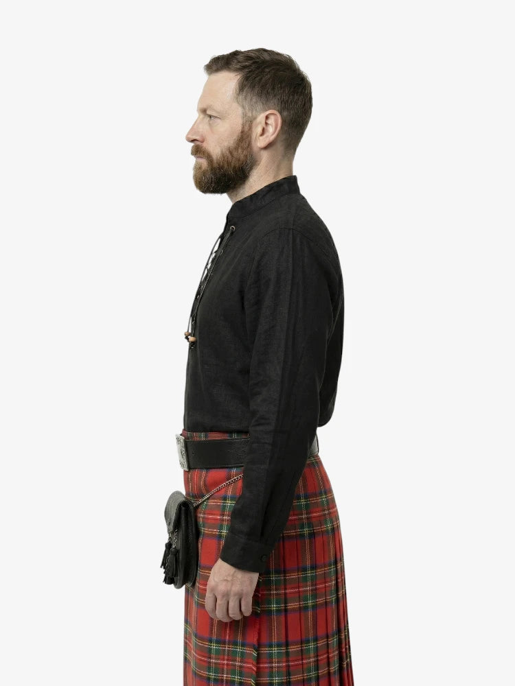 Man wearing a black shirt and red plaid kilt on a white background